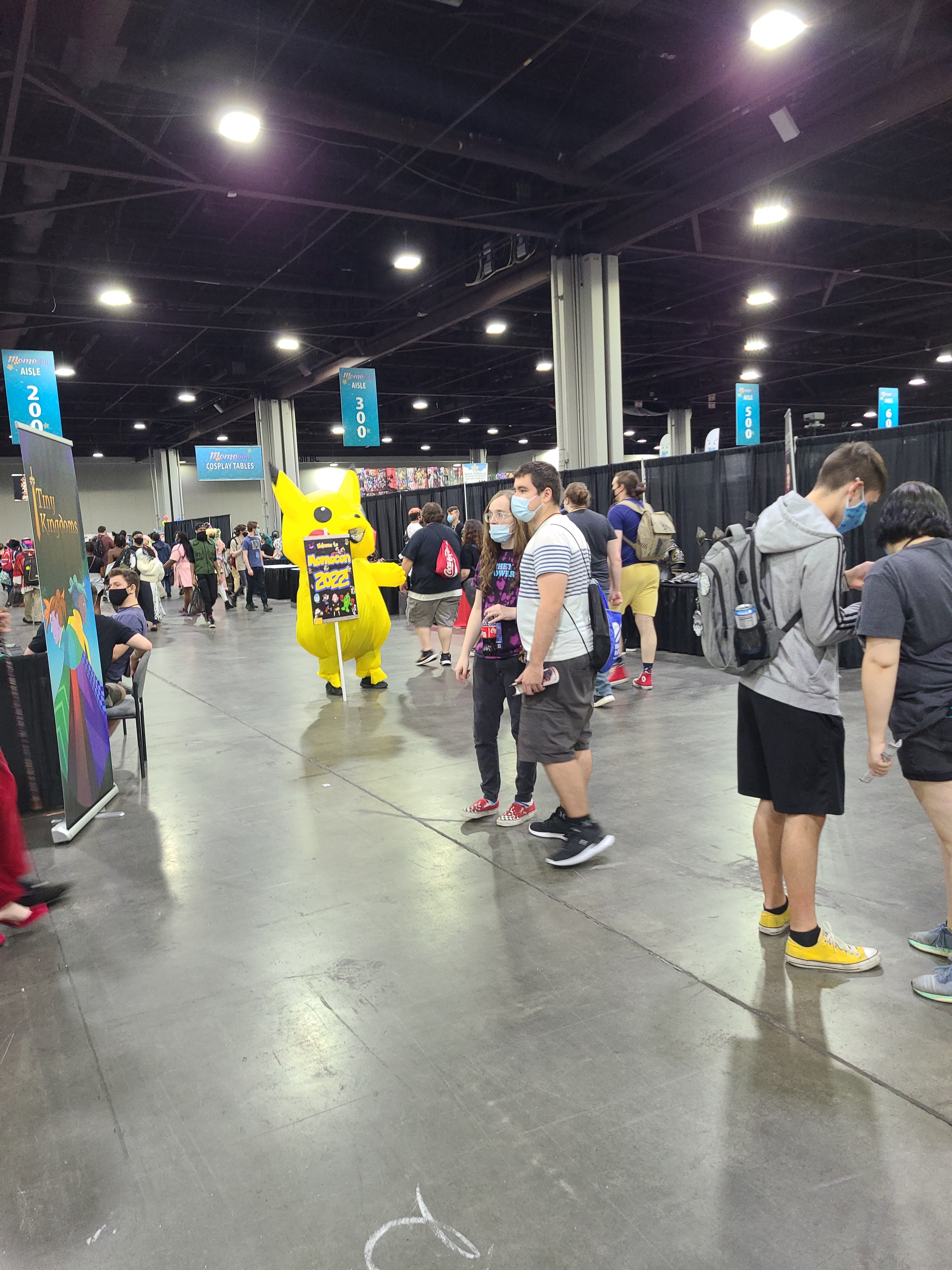 Pikachu inflatable costumed person holding a MomoCon2022 sign