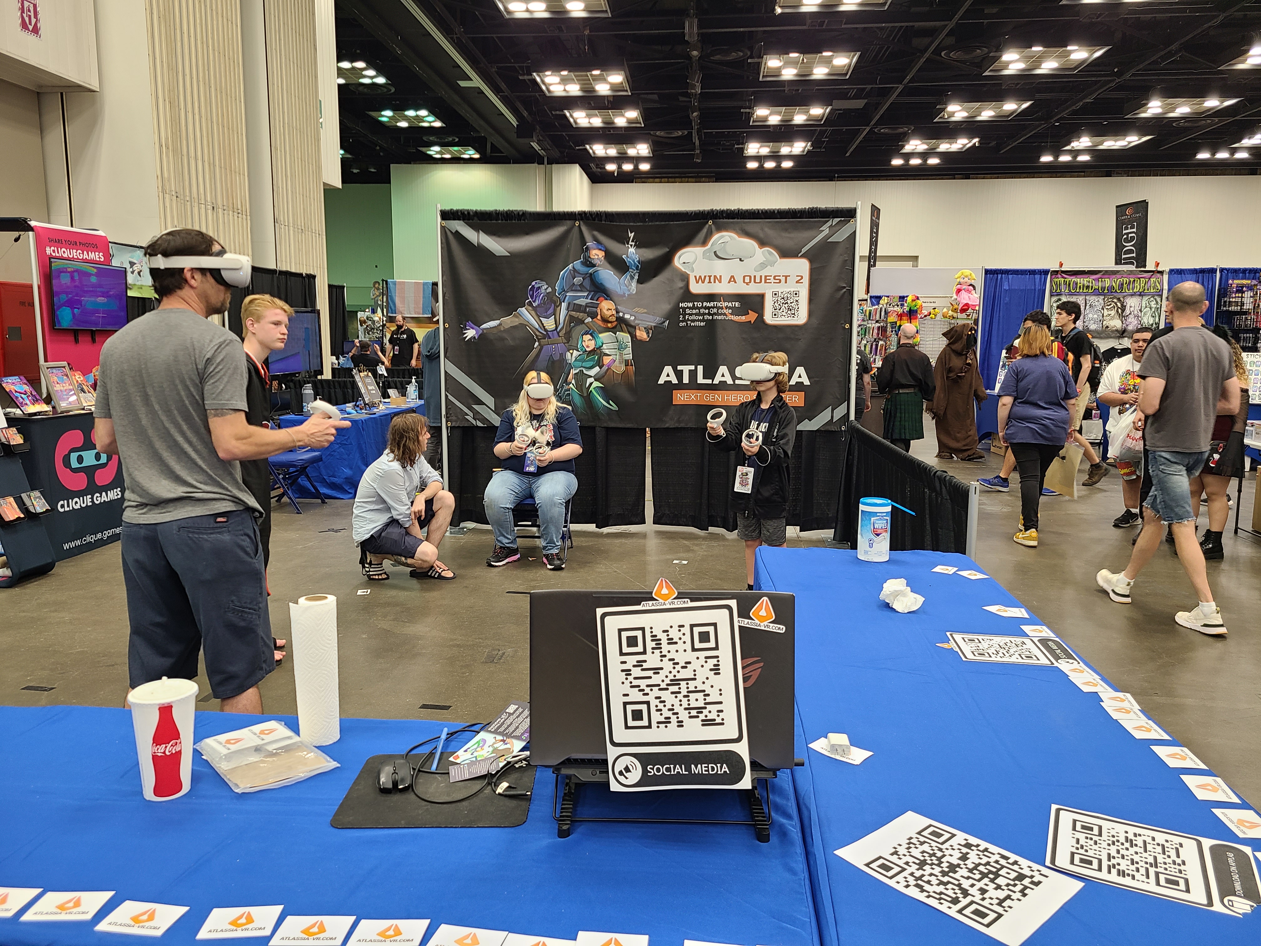 players at the atlassia booth playing standing up and sitting down