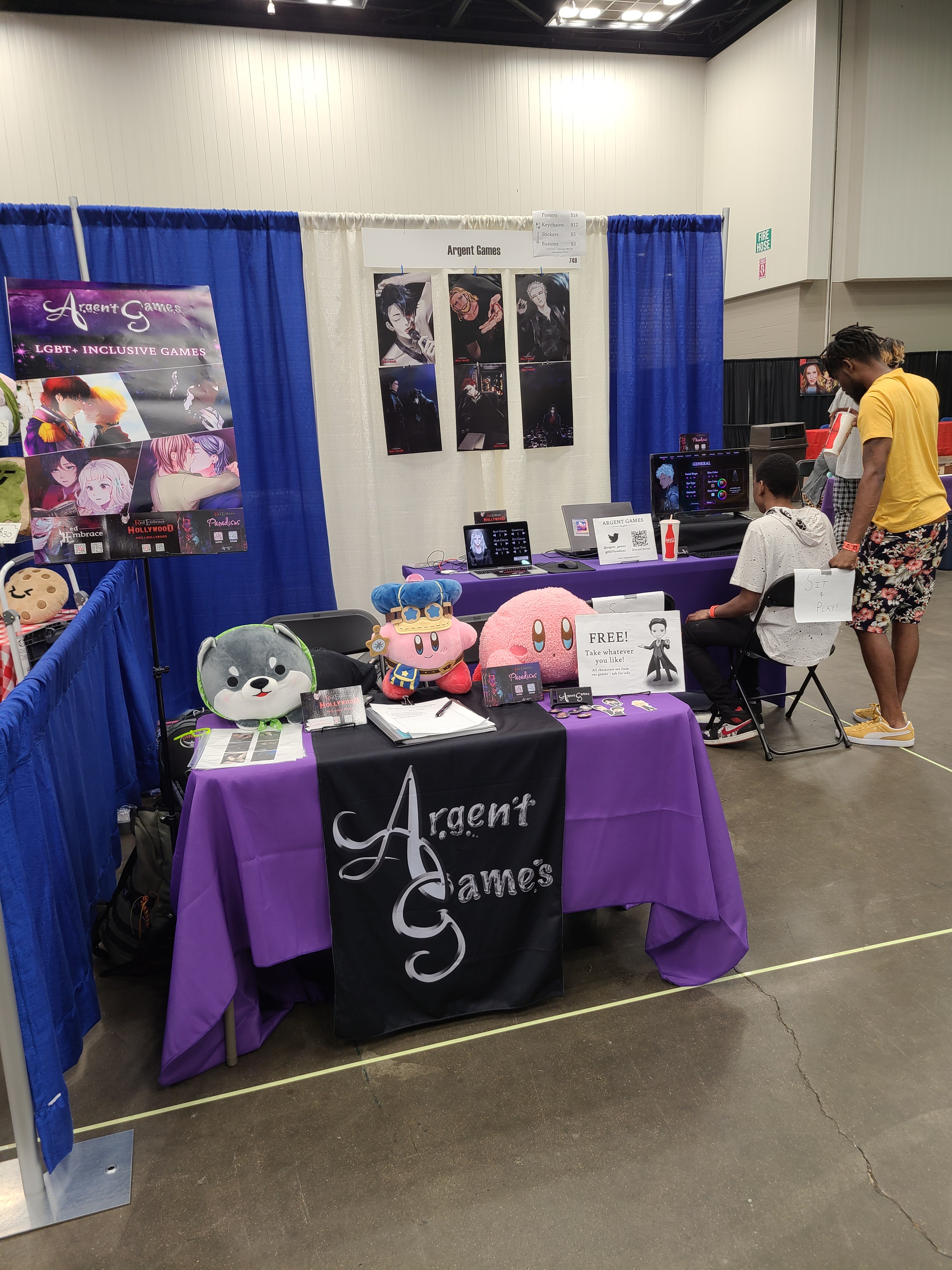 final booth setup with a shiba inu plush, kirby, and navigator kirby plush solo helming the front table
